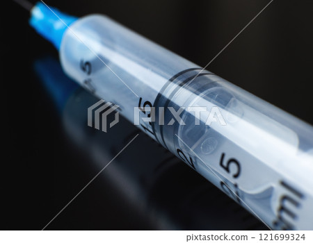 empty syringe positioned on a dark surface. High quality photo empty syringe positioned on a dark surface. High quality photo 121699324