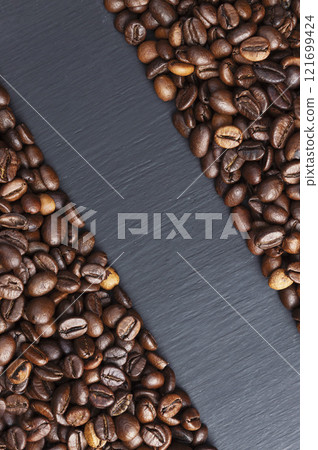 freshly roasted coffee beans.coffee shop.background from scattered coffee beans.Coffee on a dark background. Copyspace 121699424