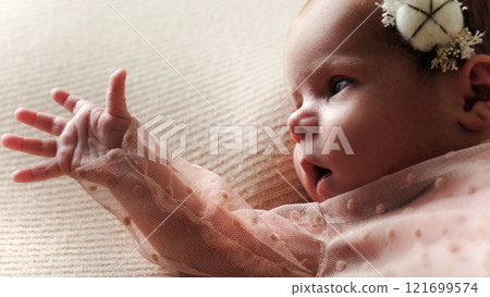 Cute Newborn Baby Girl Lying On The Bed Reached Out Hand 121699574