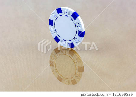 A white casino chip stands on the reflecting surface A white casino chip stands on the reflecting surface 121699589
