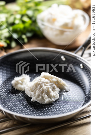 Pork lard in a non-stick cast iron pan 121699632