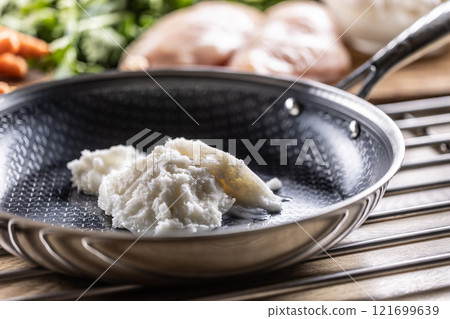 Pork lard in a non-stick cast iron pan 121699639