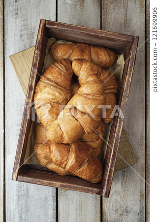 Coffee with croissants. Baked crispy croissant on a wooden board, breakfast. Homemade Croissant . 121699906