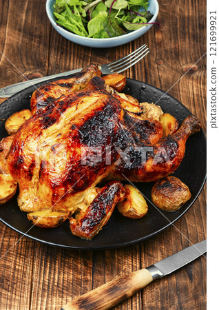 Whole roasted chicken with apples. 121699921