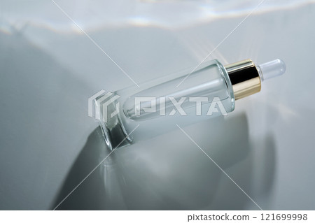Bottle of face serum with a pipette with a beautiful highlight. 121699998