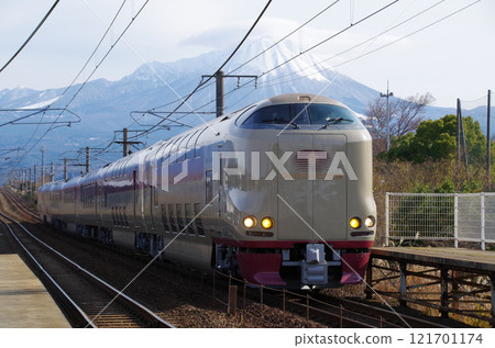 The Sunrise Izumo No. 91 sleeper express train bound for Izumo runs on the Sanin Main Line with tourists on board for the New Year's holiday, with the snow-capped Mt. Daisen in the background. 121701174