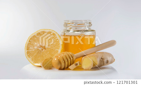 Fresh ginger, juicy lemon, and a jar of honey arranged for health support 121701301