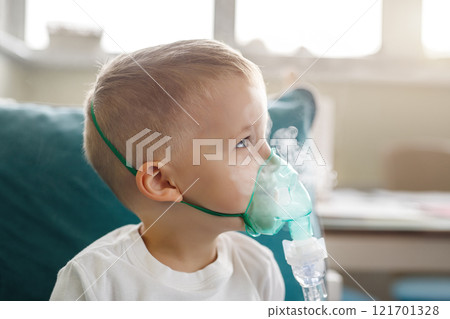 Cute little kid boy wear use medical nebulizer mask inhaling steam respiratory therapy lungs rsv allergic disease cure. Portrait child treating seasonal respiratory bronchitis cough medical inhaler Cute little kid boy wear use medical nebulizer mask inhaling steam respiratory therapy lungs rsv allergic disease cure. Portrait child treating seasonal respiratory bronchitis cough medical inhaler 121701328