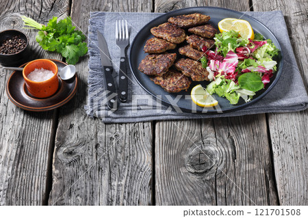 pork liver patties with fresh salad and lemon 121701508