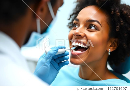 A dentist examining a patient's teeth, young black female at the dentist's. Dental health and hygiene. Close-up of patient's face and doctor's hands in gloves 121701697