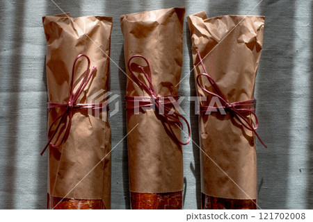 Traditional Hungarian Christmas cookies wrapped in craft paper, tied with ribbon on a green textile background. Eco-friendly packaging. Zero waste 121702008