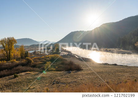 Morning Mist Over River in Grand Teton National Park with Sunlit Mountain Views. Morning Mist Over River in Grand Teton National Park with Sunlit Mountain Views. 121702199