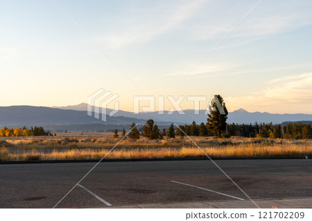 Scenic Sunrise Over Grand Teton National Park with Open Road in Foreground. Scenic Sunrise Over Grand Teton National Park with Open Road in Foreground. 121702209