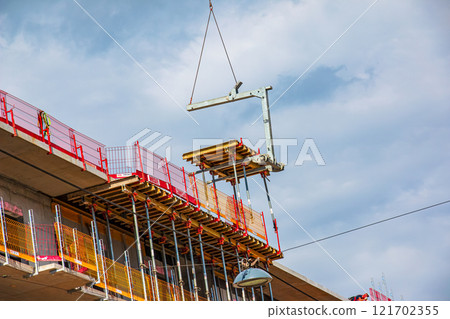 Crane and construction site against blue sky Crane and construction site against blue sky 121702355