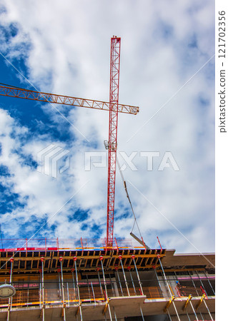 Crane and construction site against blue sky Crane and construction site against blue sky 121702356