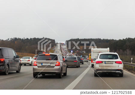 Back tail view of many cars stuck in row at highway road traffic jam cold overcast rainy winter day at Europe. Automobile accident vehicle rush hour collapse. Transportation vacation seasonal stuck Back tail view of many cars stuck in row at highway road traffic jam cold overcast rainy winter day at Europe. Automobile accident vehicle rush hour collapse. Transportation vacation seasonal stuck 121702588