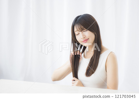 Young woman taking care of her hair Young woman taking care of her hair 121703045