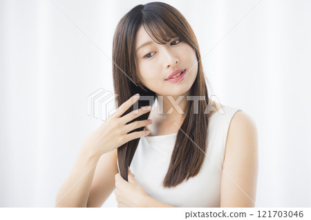 Young woman taking care of her hair 121703046