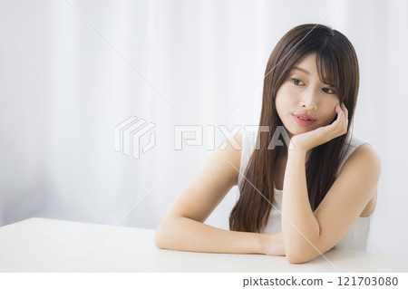 A young woman looks in the mirror and worries about her skin A young woman looks in the mirror and worries about her skin 121703080