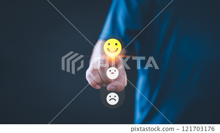 Person selects a happy face icon from a feedback scale with three emoji options, symbolizing customer satisfaction, review, and positive user experience, decision-making in an online feedback system. 121703176