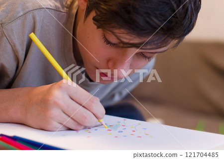 a teenage boy paints a Christmas tree before the Christmas holidays 121704485