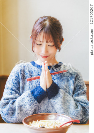 Young woman eating ramen after saying itadakimasu Young woman eating ramen after saying itadakimasu 121705267