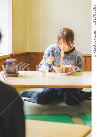 Happy young woman eating delicious ramen Happy young woman eating delicious ramen 121705269