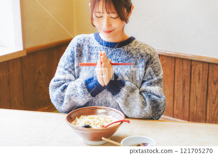 年輕女子和 itadakimasu 一起吃拉麵 年輕女子和 itadakimasu 一起吃拉麵 121705270