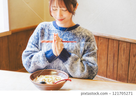 Young woman eating ramen after saying itadakimasu 121705271