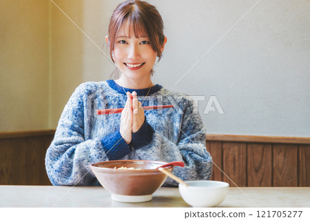 Young woman eating ramen after saying itadakimasu Young woman eating ramen after saying itadakimasu 121705277