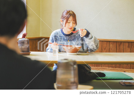 Happy young woman eating delicious ramen Happy young woman eating delicious ramen 121705278