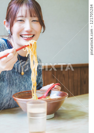 快樂的年輕女人吃美味的拉麵 快樂的年輕女人吃美味的拉麵 121705284