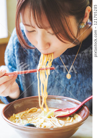 Happy young woman eating delicious ramen Happy young woman eating delicious ramen 121705285