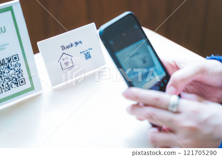 Young woman ordering via QR code 121705290