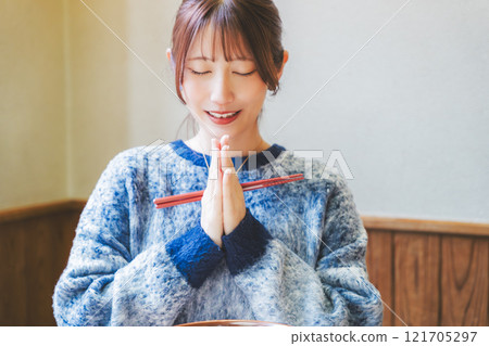 Young woman eating ramen after saying itadakimasu Young woman eating ramen after saying itadakimasu 121705297