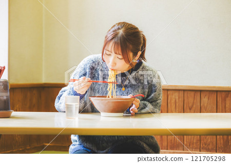 快樂的年輕女人吃美味的拉麵 快樂的年輕女人吃美味的拉麵 121705298