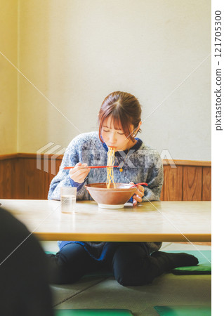 Happy young woman eating delicious ramen Happy young woman eating delicious ramen 121705300