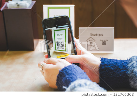 Young woman ordering via QR code 121705308