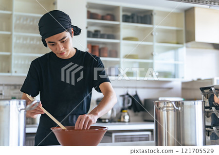 A ramen shop clerk serving ramen in a bowl 121705529