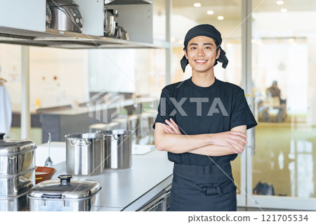 Male cook folding his arms in the kitchen Male cook folding his arms in the kitchen 121705534