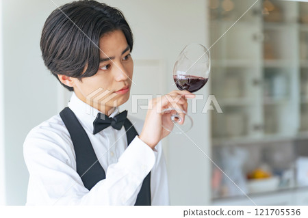 A man staring at a wine glass, a sommelier, a wine expert A man staring at a wine glass, a sommelier, a wine expert 121705536