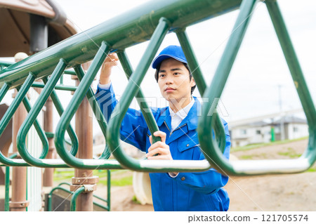 檢查公園遊樂場設備安全的男工 121705574