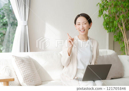 一位女士在沙發上用電腦工作 121705846