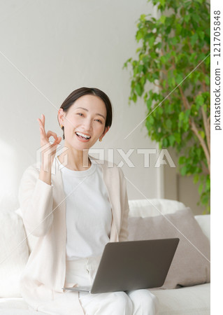 Woman working on a computer on the sofa 121705848