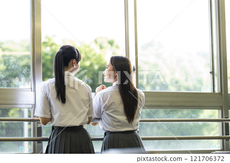 Back view of high school girls talking in classroom Back view of high school girls talking in classroom 121706372