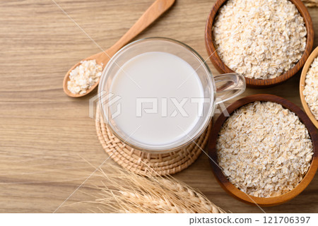 Oat milk in cup glass on wooden background, Alternative milk made from plant, non dairy Oat milk in cup glass on wooden background, Alternative milk made from plant, non dairy 121706397