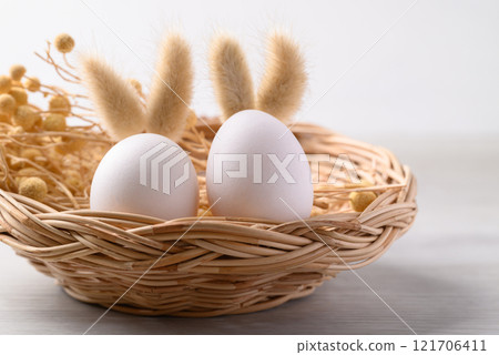 White easter eggs with bunny rabbit ears in basket, Easter concept 121706411