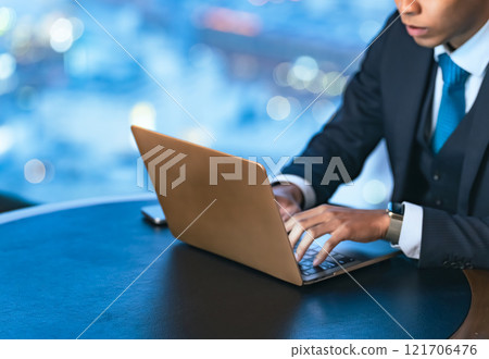 Businessman working on a laptop in a high-rise office Businessman working on a laptop in a high-rise office 121706476