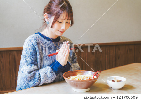 Young woman eating ramen after saying itadakimasu Young woman eating ramen after saying itadakimasu 121706509