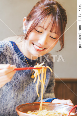 Happy young woman eating delicious ramen Happy young woman eating delicious ramen 121706530